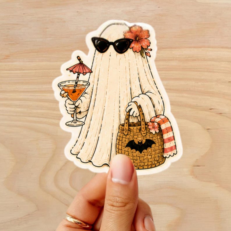 Puede incluir: Una pegatina con un fantasma de dibujos animados con gafas de sol y una flor, sosteniendo un c&oacute;ctel con un peque&ntilde;o paraguas. El fantasma lleva una bolsa tejida con un dise&ntilde;o de murci&eacute;lago y una toalla a rayas. El fantasma es de color beige claro con contornos negros.