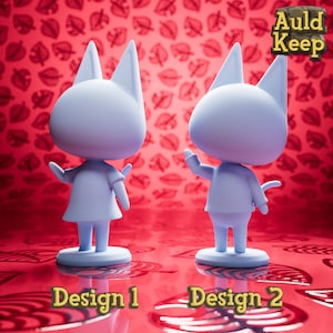 Op de afbeelding: Twee blauwe kattenbeeldjes, een staat met zijn armen omhoog en de ander staat met zijn armen langs zijn zijde. De beeldjes staan op een rode achtergrond met een bladmotief. De tekst "Auld Keep" staat in de rechterbovenhoek van de afbeelding. De tekst "Design 1" staat onder het eerste beeldje en de tekst "Design 2" staat onder het tweede beeldje.