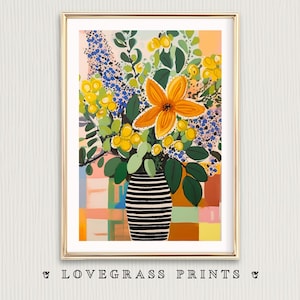 May include: A framed art print featuring a vibrant floral arrangement in a black and white striped vase. The bouquet includes orange, yellow, and blue flowers with green foliage. The background has a colorful, abstract design. The text "LOVEGRASS PRINTS" is at the bottom.