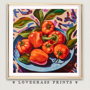 May include: A framed art print featuring a still life of orange bell peppers in a blue bowl, surrounded by green leaves. The background has a colorful abstract pattern. The text "LOVEGRASS PRINTS" is at the bottom.