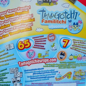 K&ouml;nnte beinhalten: Eine Tamagotchi Familitchi-Verpackung mit farbenfrohen Grafiken und Text. Die Verpackung zeigt verschiedene Zeichentrickfiguren, die Zahl 65 und den Text "World Famous". Die Website Tamagotchieurope.com ist ebenfalls zu sehen.