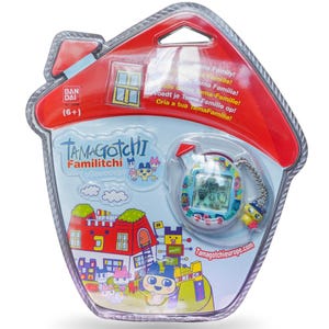 K&ouml;nnte beinhalten: Ein Tamagotchi Familitchi elektronisches Haustierspiel in einer hausf&ouml;rmigen Verpackung. Die Verpackung ist rot und aus transparentem Kunststoff, mit einer farbenfrohen Grafik der Tamagotchi-Charaktere und einer Stadtlandschaft. Das Spiel ist ein kleines Handheld-Ger&auml;t mit einem Bildschirm.
