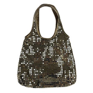May include: A bronze-coloured tote bag, covered in small, reflective sequins. The sequins create a textured surface. The handle and trim are also bronze. The bag is designed for carrying items, and would be suitable for a variety of uses.