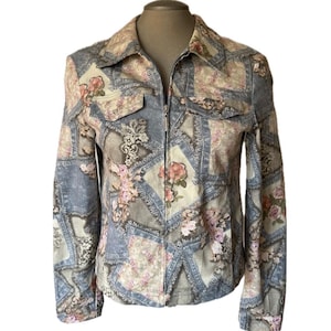 May include: A floral print jacket with a full zip. The jacket has a patchwork design with floral and ornamental patterns in blue, beige, and pink. It features two chest pockets and long sleeves.