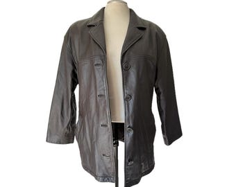 May include: A dark brown leather jacket featuring a classic collar, long sleeves, and a front button closure with four visible buttons. The jacket has a smooth finish and a structured fit, displayed on a mannequin against a plain white background.