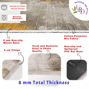 May include: A close-up of a rug with a gray and yellow design. The rug has a 6 mm non-slip woven base, a 5 cm fringe, and a total thickness of 8 mm. It is made of cotton-polyester mix fabric and has a PVC dot base. The rug is machine washable and suitable for robot vacuum cleaners.