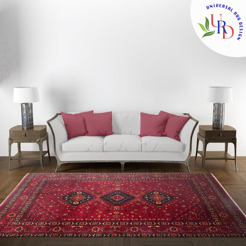 May include: A red, black, and cream patterned rug with a geometric design. The rug is laid out on a wooden floor in front of a white sofa with red pillows.