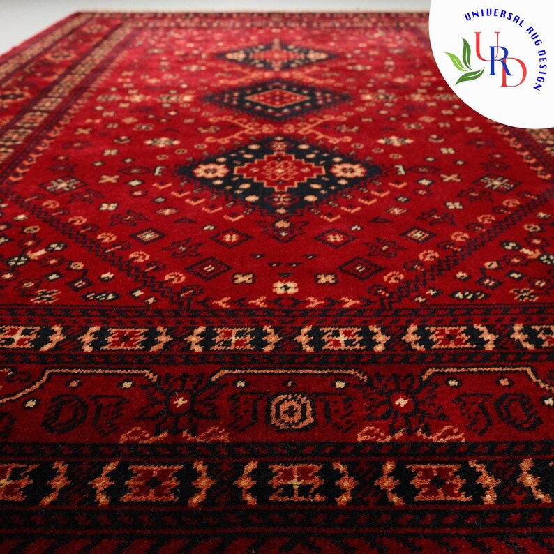 May include: A red rug with a traditional Persian design featuring intricate patterns in black and cream. The rug has a central medallion and a border with repeating motifs.