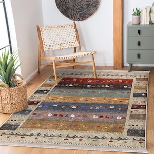 May include: A rectangular area rug with a striped pattern in shades of red, blue, brown, and beige. The rug has a fringed edge and is placed on a wooden floor. A wooden chair and a woven basket are in the background.