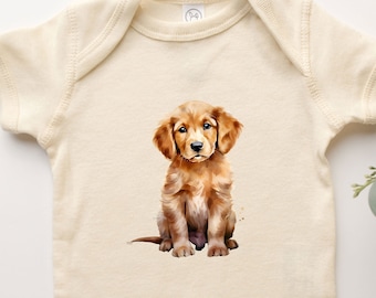 Könnte beinhalten: Ein cremefarbener Baby-Strampler mit einer Aquarell-Illustration eines Golden Retriever-Welpen, der auf weißem Hintergrund sitzt.