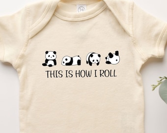 May include: A cream-colored baby onesie with short sleeves features a black and white graphic of five pandas in different poses. The text "This is how I roll" is printed below the pandas.