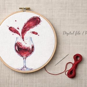 May include: A cross-stitch embroidery hoop features a detailed image of a wine glass with red wine splashing out. A needle and red thread are next to the hoop. The text "Digital file / PDF" is visible.