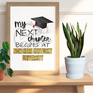 May include: A framed print with a graduation cap and diploma design. The text reads "My next chapter begins at Northern Kentucky University".