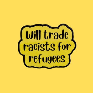 May include: A yellow sticker with black text that reads "Will trade racists for refugees." The text is inside a yellow cloud-shaped border with a black outline. The background is a solid yellow.