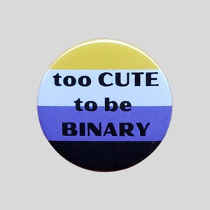 May include: A round button with a yellow, white, purple, and black striped design. The text "too CUTE to be BINARY" is printed in black on the button.