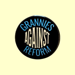 May include: A circular black badge featuring the text "GRANNIES AGAINST REFORM" in white and light blue. The words are arranged in a circular design, with the text stacked vertically.