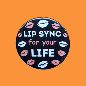 May include: Black and white button with the text "Lip Sync for your Life" surrounded by pink and white lips.