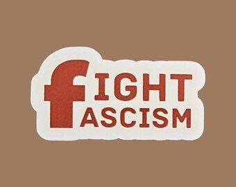 May include: A sticker with the words "FIGHT ASCISM" in red block letters. The letter "F" is stylized. The text is on a white background with a brown border.
