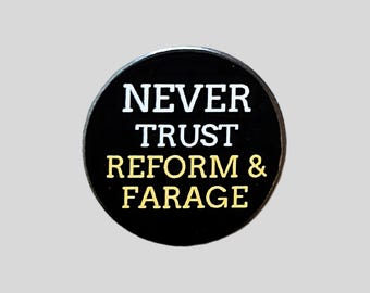 May include: A round, black pin with the white text "NEVER TRUST" above the gold text "REFORM & FARAGE". The pin is centered on a light gray background.