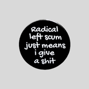May include: A circular black badge with white lettering. The text states "Radical left scum just means I give a shit". The badge is displayed on a pale grey backdrop.
