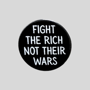 May include: A circular black badge featuring the white text "FIGHT THE RICH NOT THEIR WARS". The badge is set against a pale grey backdrop. The text is in a bold, sans-serif typeface.