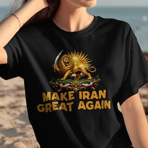 Puede incluir: Camiseta negra con un diseño de león dorado sosteniendo una espada, un sol radiante y el texto "MAKE IRAN GREAT AGAIN" en dorado. El diseño incorpora elementos de la bandera iraní. Una camiseta casual para uso diario.