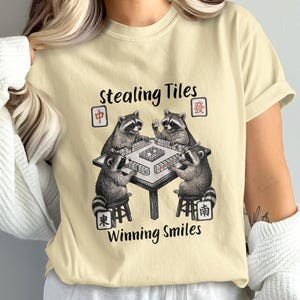 May include: A white ceramic mug with a black handle and the text "But First, Coffee" in a handwritten style. The mug is on a white surface. The mug is likely 11 ounces.