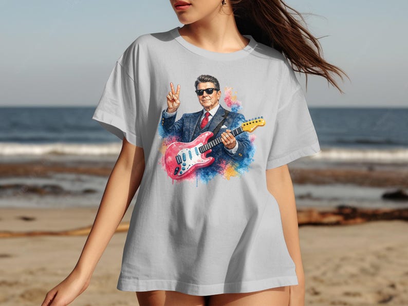 Ronald Reagan graphic on a light gray t-shirt, holding a pink guitar.