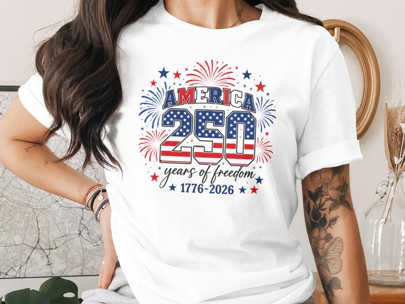 White t-shirt with "America 250 years of freedom 1776-2026" text and fireworks.