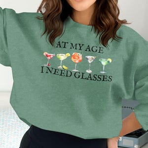 Sudadera con texto "A mi edad necesito gafas", sudadera única para amantes de las bebidas, sudadera con cócteles divertidos, sudadera para beber durante el día, sudadera para bar