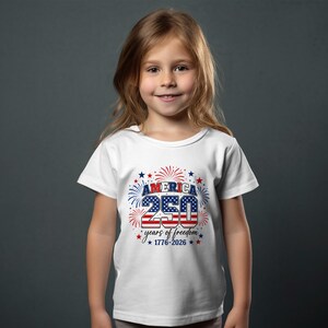 Girl wearing white t-shirt with "America 250 Years of Freedom 1776-2026" graphic.