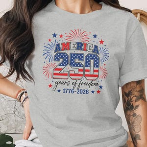 Gray t-shirt with "America 250 years of freedom 1776-2026" in red, white, and blue.