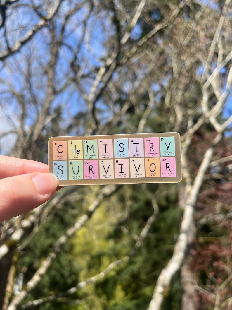 May include: A sticker with the word "CHEMISTRY" spelled out using the chemical element symbols for each letter. The word "SURVIVOR" is spelled out below using the same method.