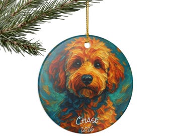 May include: A round ceramic ornament featuring an impressionistic painting of a golden-brown dog with curly fur against a teal background. The name Chase and the year 2026 are printed in white script at the bottom. It hangs from a gold string.
