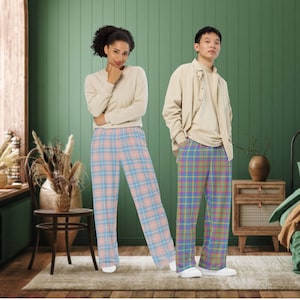 May include: Two people wearing plaid pants. The person on the left is wearing light blue and pink plaid pants. The person on the right is wearing multi-colored plaid pants.
