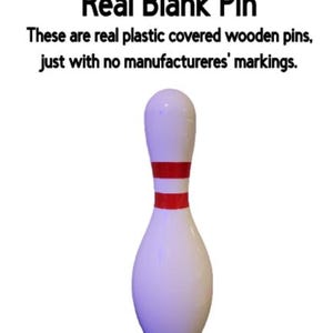 May include: A white bowling pin with two horizontal red stripes around the neck. The text above reads: New type of pin available! Real Blank Pin. These are real plastic covered wooden pins, just with no manufactureres' markings.