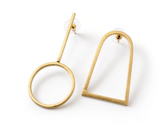 May include: A pair of gold-toned earrings featuring mismatched geometric shapes. One earring consists of a thin vertical bar attached to a circular hoop, while the other is an arch-shaped frame. Both earrings include clear plastic earring backs.