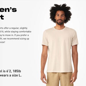 May include: A beige short-sleeved t-shirt with a crew neckline. Text on the left reads: Men's Fit. Our shirts offer a regular, slightly tailored fit, while staying comfortable and easy to move in. If you prefer a looser fit, we recommend sizing up by one size! Model is 6'2, 185lb and wears a size L.
