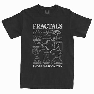 May include: A black short-sleeve t-shirt featuring a white graphic print of various mathematical fractal diagrams and geometric structures. The text FRACTALS is printed at the top, and the text UNIVERSAL GEOMETRY is printed at the bottom.