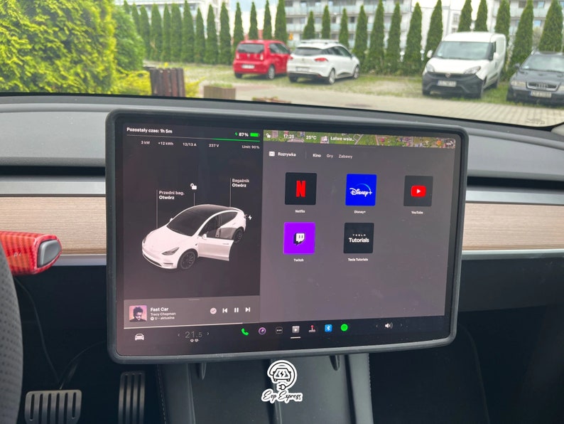 K&ouml;nnte beinhalten: Ein Tesla Model Y Touchscreen-Display, das eine Vielzahl von Apps zeigt, darunter Netflix, Disney+, YouTube, Twitch, Tesla Tutorials und einen Musikplayer. Der Bildschirm zeigt auch eine Karte mit einer geplanten Route und ein Autosymbol, das die Position des Fahrzeugs darstellt.