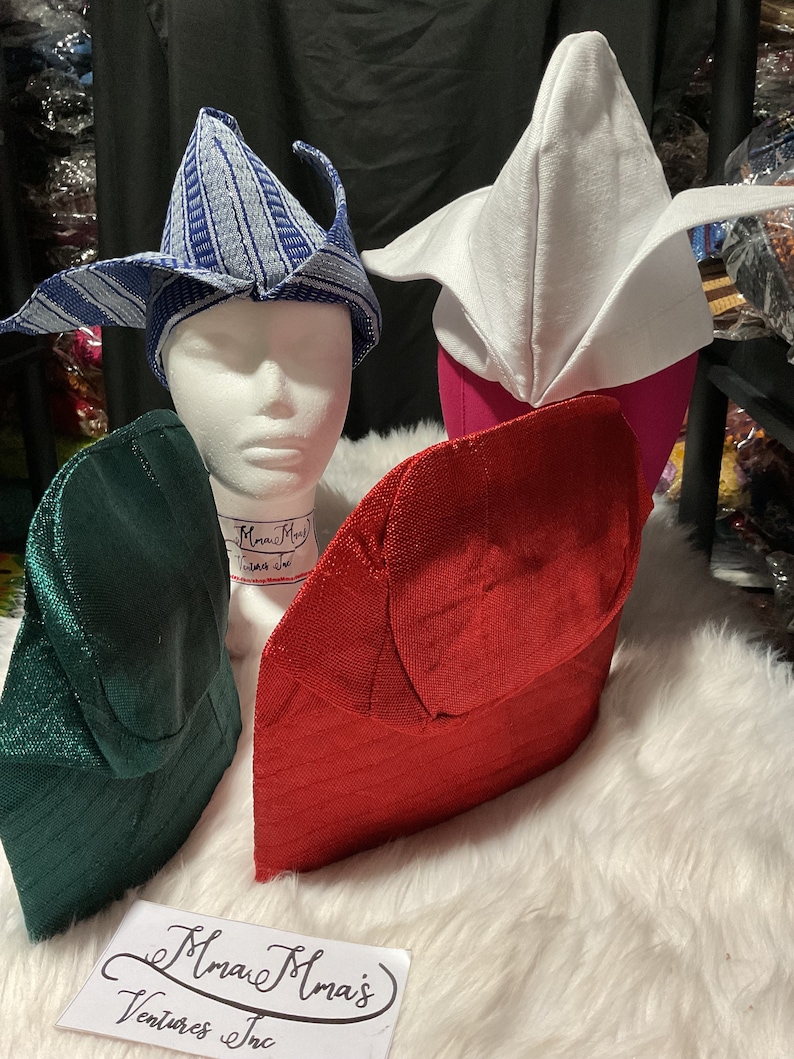 May include: A collection of colorful, textured hats in various styles. The hats include a blue and white patterned hat, a white hat, a red hat, and a green hat. The hats are displayed on mannequin heads.