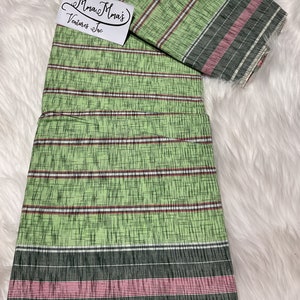 May include: Green and white striped fabric with a pink and black border. The fabric is folded in half and has a label that says "Mma Mma's Ventures Inc."