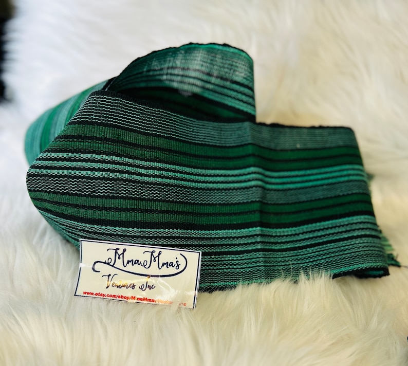 May include: Green and black striped fabric with a tag that reads "Mmau Mrai's Ventures Inc. www.etsy.com/shop/mmaumrai"