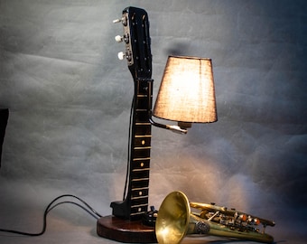 Ein originelles Geschenk: eine Tisch- Loftlampe, die aus dem Hals einer sechssaitigen Gitarre besteht.