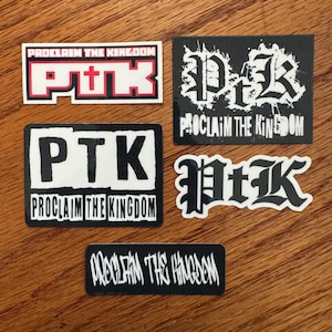 May include: A collection of five stickers with the text "PROCLAIM THE KINGDOM" and the initials "PTK". The stickers feature various designs, including a red and white rectangular sticker, a black and white design, and a black and white rectangular sticker.