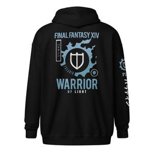 以下が含まれることがあります： 黒色のパーカー。背面に「FINAL FANTASY XIV」と「WARRIOR OF LIGHT」の文字が白と水色でプリントされています。シールドエンブレムと日本語のテキストもデザインされています。フードと長袖付き。