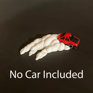May include: A red toy car with a black hood sits atop a white cloud-shaped base. The text "No Car Included" is displayed in white at the bottom of the image, set against a dark background.