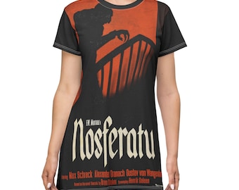Op de afbeelding: Een zwarte t-shirtjurk met een vintage filmposterontwerp. De poster toont een silhouet van een vampier op een trap met de titel "Nosferatu" in een gotische lettertype. De poster bevat ook de namen van de acteurs en de regisseur.