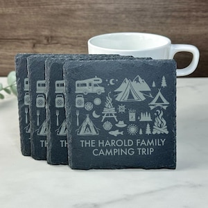 Puede incluir: Juego de seis posavasos de pizarra negra con un diseño blanco de iconos de camping y el texto "The Harold Family Camping Trip".