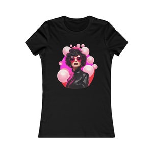 May include: A black women's t-shirt with a graphic of a woman with pink heart-shaped sunglasses and pink bubbles around her head.
